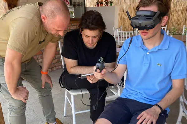 Instruktor pomaže polazniku sa FPV naočarima tokom vežbe na simulatoru